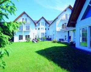 ein großes weißes Haus mit einem grünen Hof in der Unterkunft Hotel Landhaus Krombach in Elkenroth