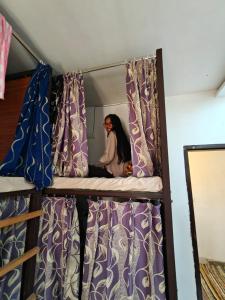 a person sitting on top of a bunk bed at Backpackers Station in Jammu