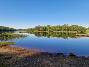 a large lake with trees reflecting in the water at EFS-gården Åsljunga Solvik in Åsljunga +3 photos