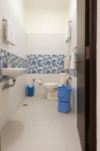 un baño con inodoro y lavabo en Tirathsheela Homestay, en Amritsar 2 fotos más