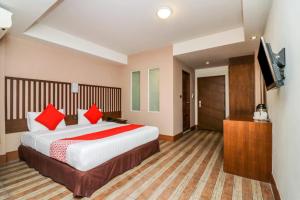 a bedroom with a large bed and a flat screen tv at Dancenter JA Siam City in Pattaya