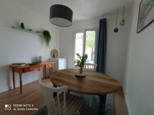 a dining room table with a vase of flowers on it at B&B du Marais à 2km de Marennes, une chambre d'hôtes au bord du canal, proche plages et Vélodyssée in Saint-Just