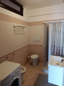 a bathroom with a toilet and a sink and a washing machine at Relax beach San Vito lo Capo in San Vito lo Capo