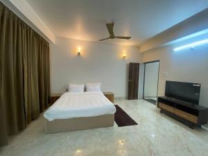 a bedroom with a bed and a flat screen tv at Home away from home in Gangtok