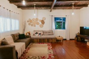 Una sala de estar con un sofá y un televisor. en Sítio incrível 4Q c/ piscina e área de churrasco, en Vítor Hugo