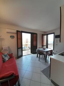 a living room with a red couch and a table at Relax beach San Vito lo Capo in San Vito lo Capo +13 photos