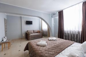 a bedroom with a large bed and a couch at Перлина Карпат in Pystanʼ +69 photos