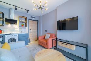 a living room with a couch a chair and a tv at Aria Riva Apart Hotel in Alanya