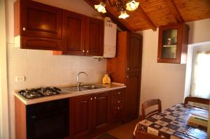 a kitchen with wooden cabinets and a sink and a stove at Antico Castello in Seborga