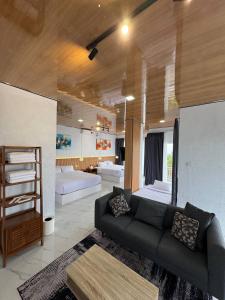 a living room with a couch and some beds at SunSet Lawu Kemuning, Villa, Full House 3 Bed, Free BBQ, Free Float Light Breakfast in Karanganyar +18 photos