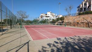 a tennis court in front of a building at Hacienda Apartment in Sucina