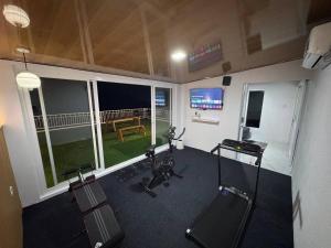 a room with a gym with bikes and a table at SunSet Lawu Kemuning, Villa, Full House 3 Bed, Free BBQ, Free Float Light Breakfast in Karanganyar