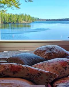 a view of a lake from a window with pillows at Nature Dream Days in Muhos