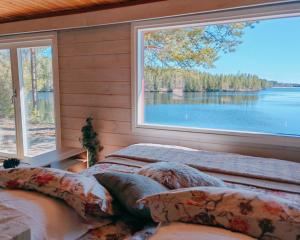 a bedroom with a large window overlooking a lake at Nature Dream Days in Muhos