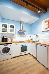 a kitchen with white cabinets and a washer and dryer at Casina de Santa Ana I By Silastur in Siero