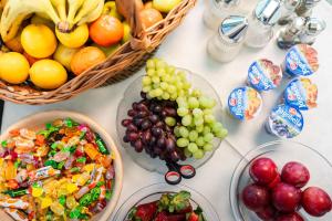a table with bowls of fruit and baskets of fruit at Bed & Breakfast Villa Terezija in Baška