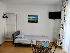 Un dormitorio pequeño con una cama y un televisor. en Villa Alex, en Władysławowo
