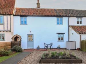 a white house with a patio in front of it at Spring Cottage in Norwich