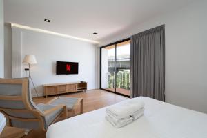 a bedroom with a bed and a chair and a window at Townhouse in Khet Phayathai - Ari in Bangkok