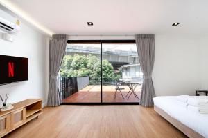 a bedroom with a bed and a sliding glass door at Townhouse in Khet Phayathai - Ari in Bangkok