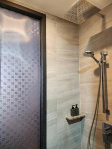 a shower with a glass door in a bathroom at The Edge Central Pattaya - Unique & Luxurious in Pattaya Central