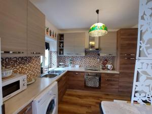 a kitchen with wooden cabinets and a sink and a chandelier at Al Teatro Antico Rooms & House in Taormina