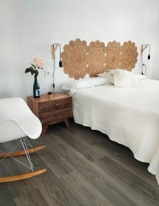 a bedroom with a bed and a chair and a table at Casa Martí in El Vendrell