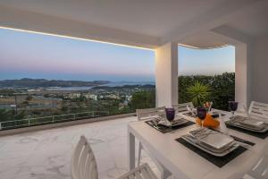 a dining room with a table and chairs on a balcony at Sea Breeze Retreat with Private Pool in Saronida