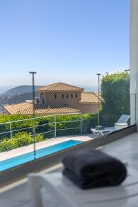 a black pillow sitting on a table next to a swimming pool at Sea Breeze Retreat with Private Pool in Saronida