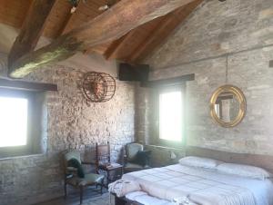 a bedroom with a bed and a stone wall at SEGARATI RELAX la Romantica in Bardi