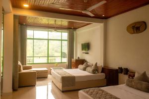 a bedroom with two beds and a couch and a window at Ramboda Falls PLC in Ramboda +61 photos