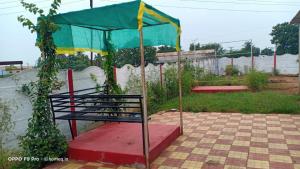 a bench under a tent in a garden at Farm House with swimming pool near Hyderabad in Wangāpalli