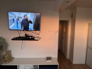 a television hanging on a wall in a room at 2 Superbes chambres d hôte dans un appartement avec magnifique vue sur Paris in Sucy-en-Brie