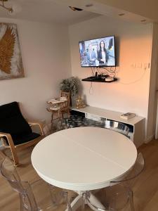 a white table in a room with a tv on the wall at 2 Superbes chambres d hôte dans un appartement avec magnifique vue sur Paris in Sucy-en-Brie