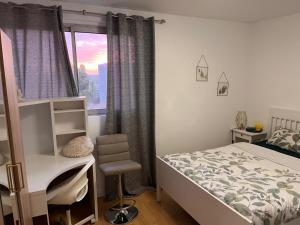 a bedroom with a bed and a desk and a window at 2 Superbes chambres d hôte dans un appartement avec magnifique vue sur Paris in Sucy-en-Brie