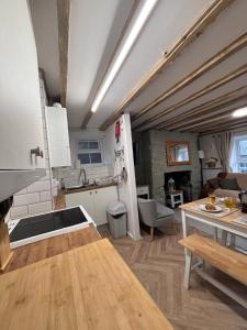 eine Küche mit weißen Schränken und einem Holztisch in der Unterkunft The Cottage on the Rock in Barmouth