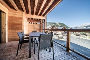a table and chairs on the deck of a house at Apartment Montami, Châtel - by EMERALD STAY in Châtel