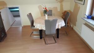 a dining room table with chairs and a vase of flowers on it at Appartement Lübeck St. Lorenz in Lübeck