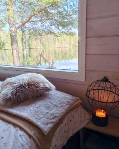 a bedroom with a window and a bed and a lamp at Nature Dream Days in Muhos