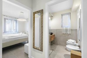 a bathroom with a mirror and a bed and a sink at Appartamento 30 NODI Torbole - Happy Rentals in Nago-Torbole