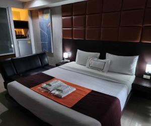 a hotel room with a large bed and a couch at Dancenter Bangkok Cha Cha Suite in Bangkok