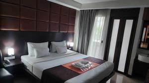 a bedroom with a large bed with two towels on it at Dancenter Bangkok Cha Cha Suite in Bangkok