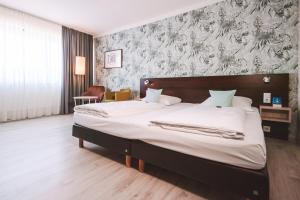 a bedroom with a large bed in a room at Best Western Hotel Ambassador in Baunatal