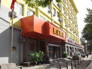 a building with an orange canopy on a city street at Home Inn Beijing Xiaoxitian in Beijing