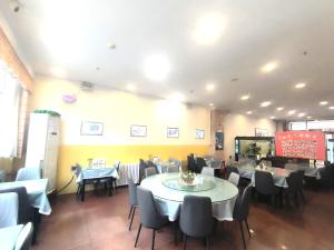 a dining room with tables and chairs in a restaurant at Home Inn Beijing Xiaoxitian in Beijing