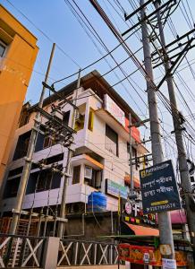 グワーハーティーにあるHoliday Inn Guest House Near Nemcare Hospitalの側面に看板が多く建つ建物