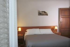 a bedroom with a bed with two lamps and a door at Villa Astoria in Taormina