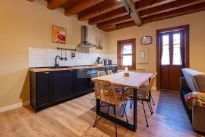 a kitchen and dining room with a table and chairs at Casina de Santa Ana II By Silastur in Siero