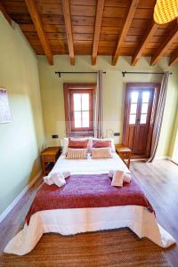 a bedroom with a large bed in a room with wooden ceilings at Casina de Santa Ana II By Silastur in Siero