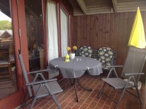 a table and chairs on the porch of a house at Ferienwohnung Michel in Glücksburg